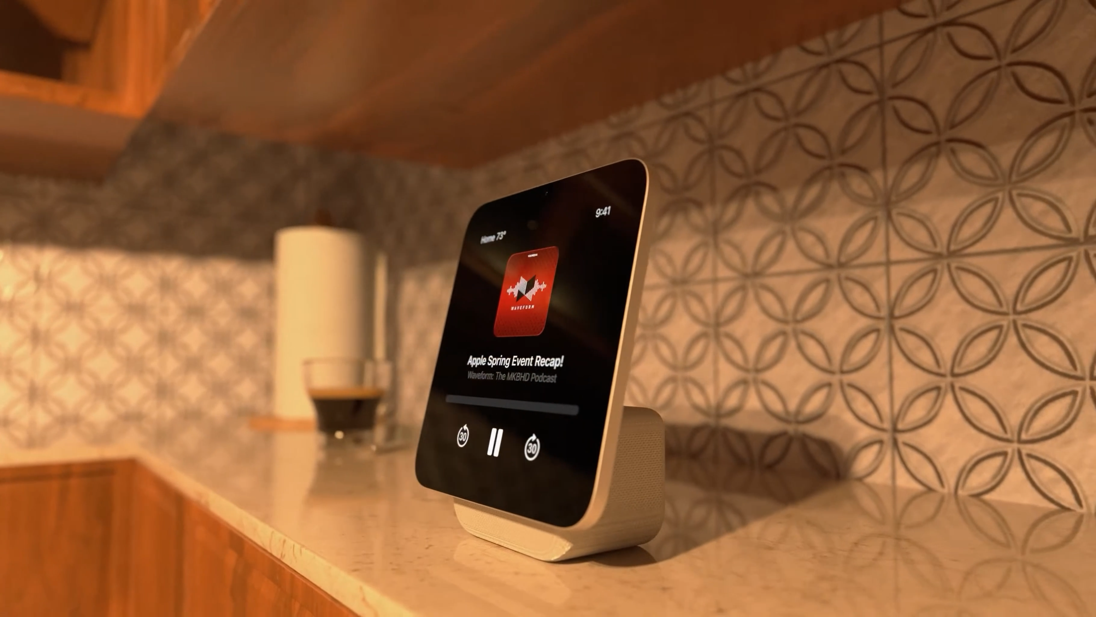 Auto-generated description: A tablet is displayed on a stand in a kitchen, playing an audio podcast titled Apple Spring Event Recap.